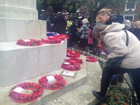 Locals read the poem displayed at the war memorial after the remembrance service